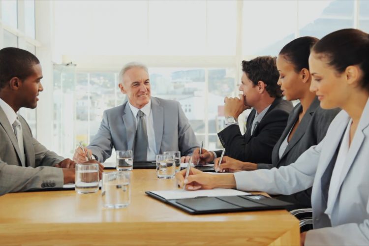 Coworkers sit across table with sticky notes