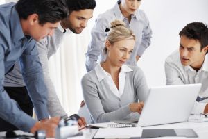 Team of business professional looking at laptop