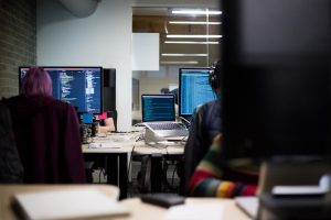 Two hackers working in a room