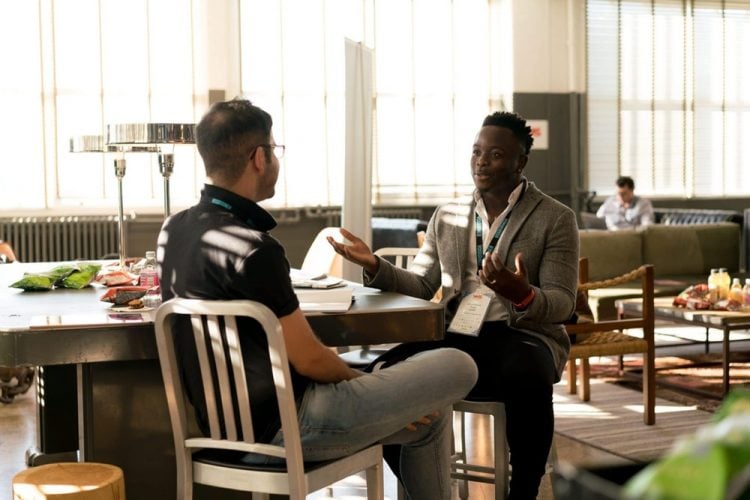 Two men sit facing each other having a conversation