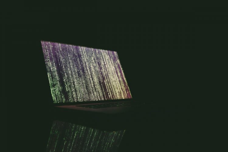 green lines of code on a laptop in the dark